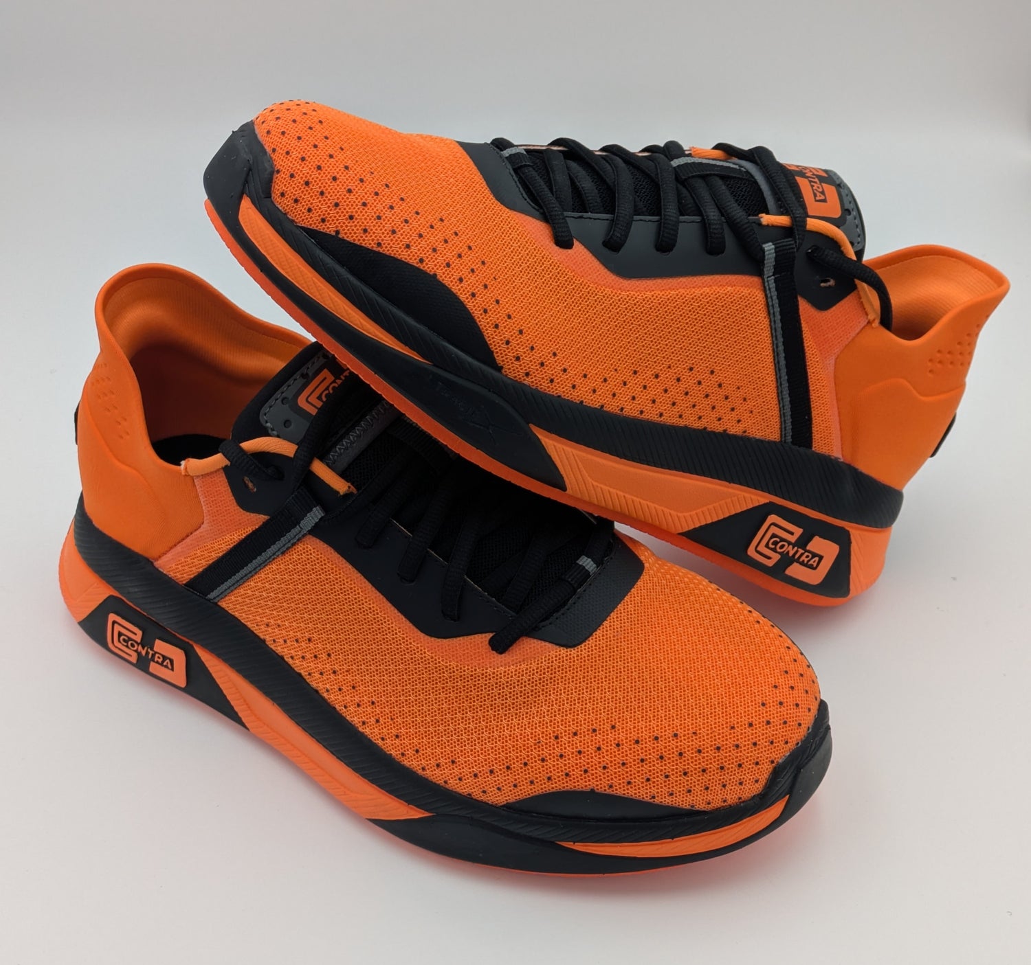 Orange and black athletic shoes on a light gray background