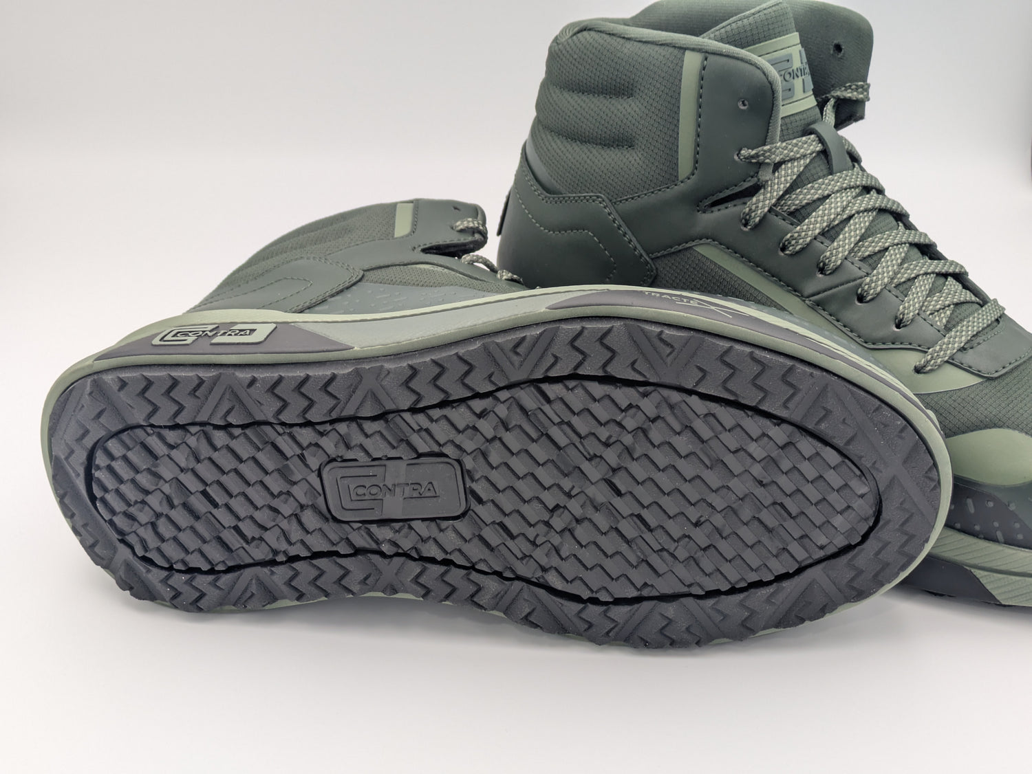 Pair of green high-top sneakers with black soles on a white background
