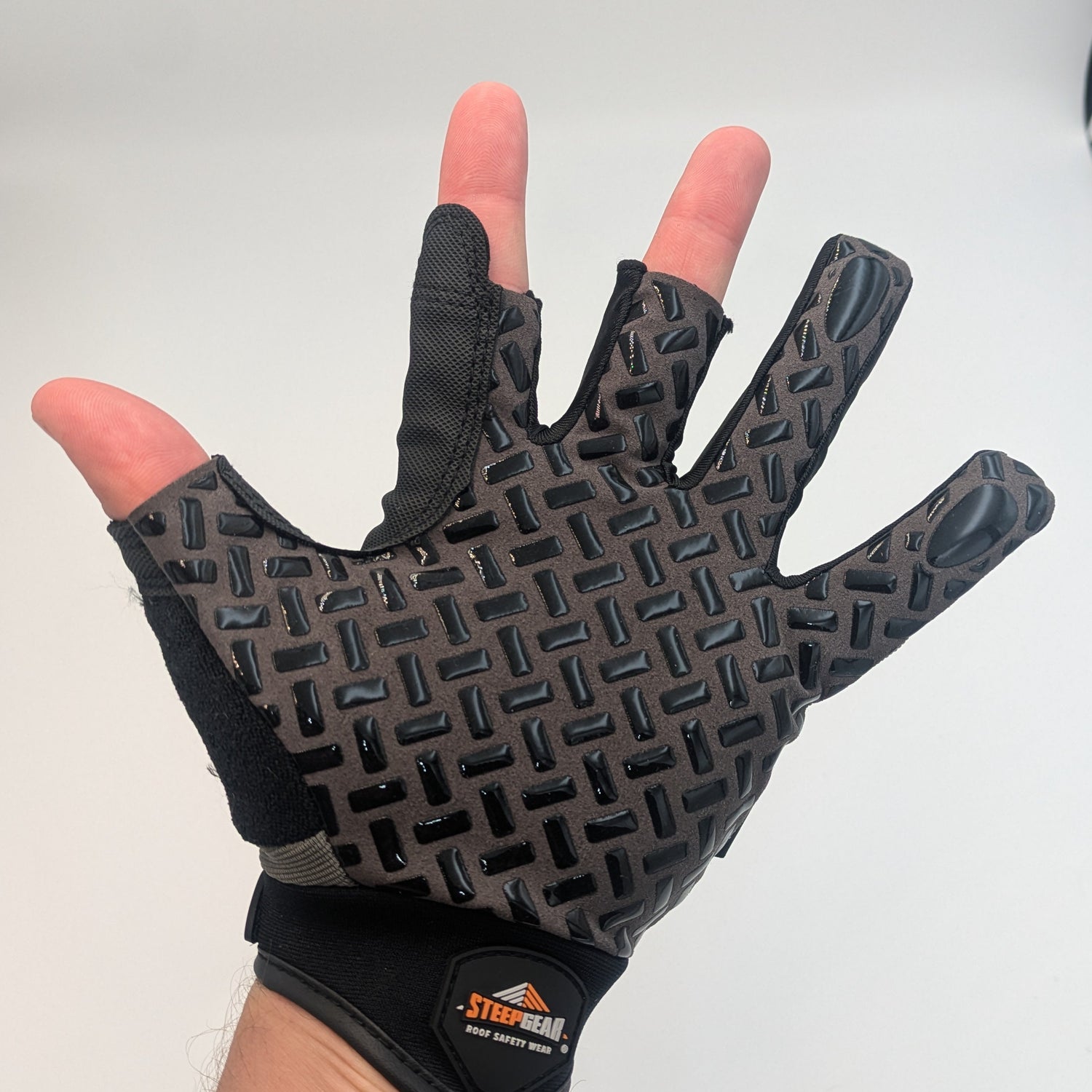 Black half-finger glove with textured palm on a white background